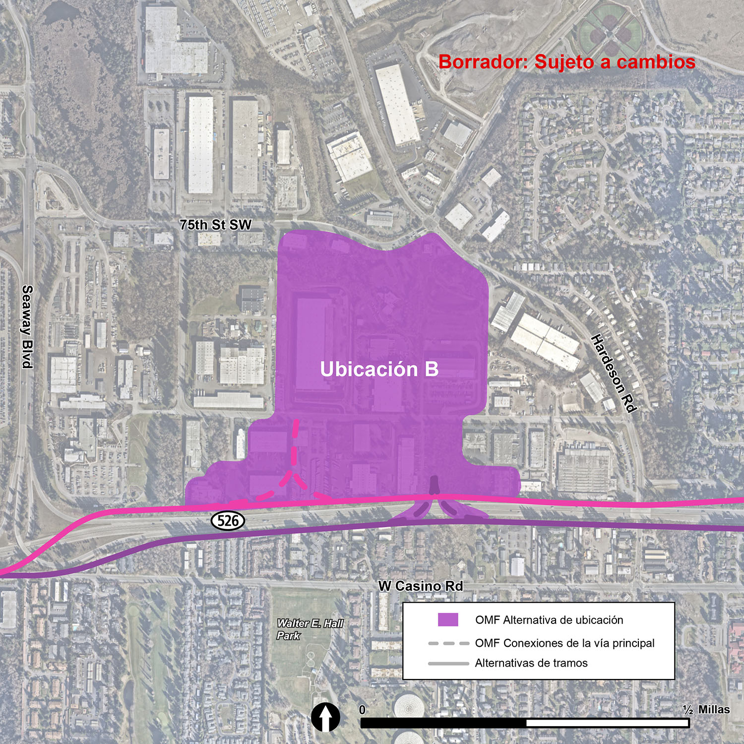 La ubicación de la OMF Site B se ilustra con una figura púrpura. Los límites de la OMF Site B son la State Route 526 al sur, 75th Street Southwest y Hardeson Road al norte, y entre las propiedades industriales existentes al este y al oeste. Las vías/rieles principales, que permiten que los trenes entren y salgan de la OMF Site B, se muestran con líneas punteadas.